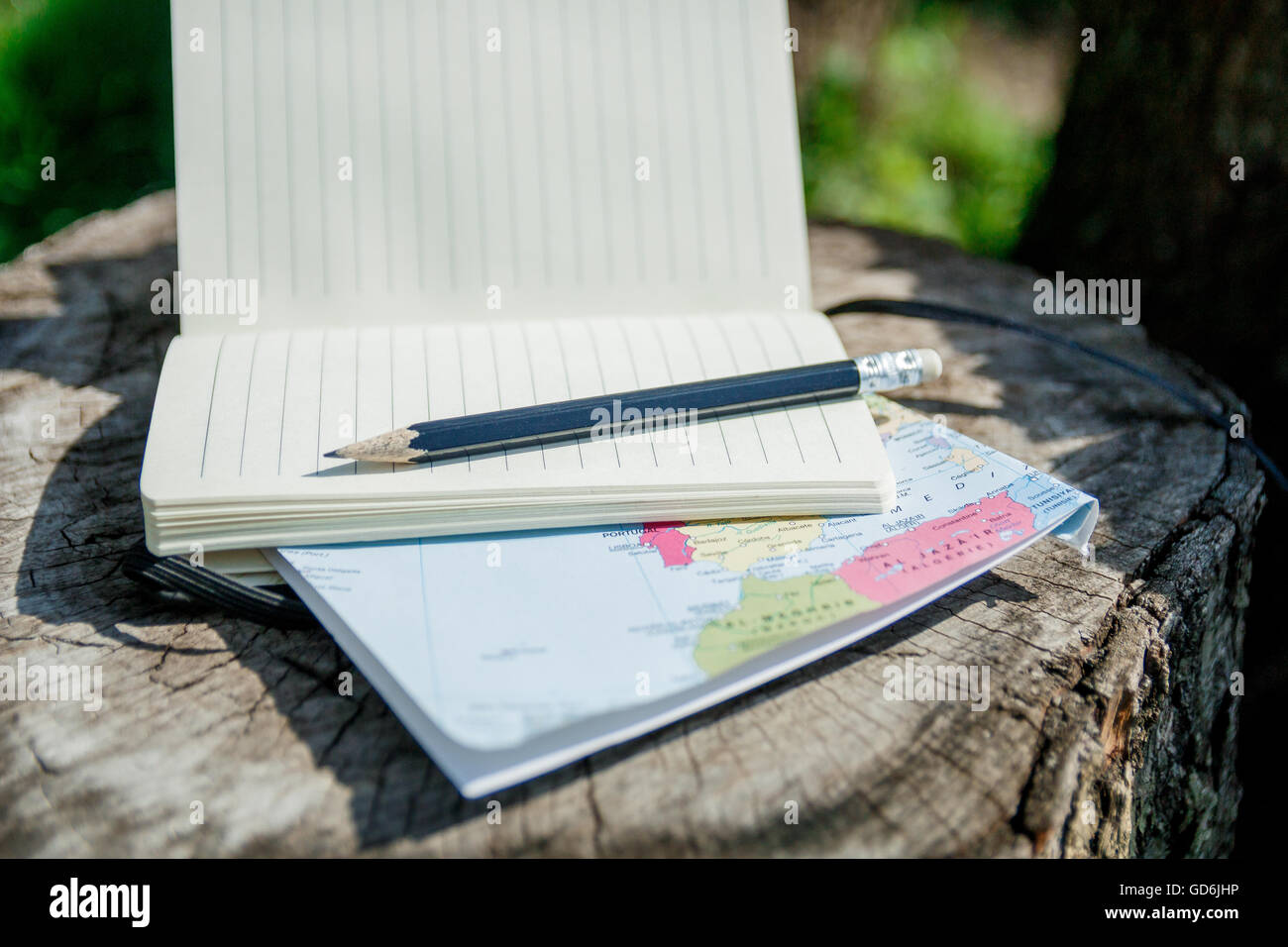 planning travel. Map, note and pencil on wooden background. Stock Photo