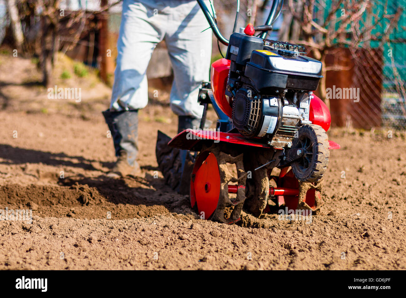 Man working in the garden with Garden Tiller. Garden tiller to work, closeup. Man with tractor