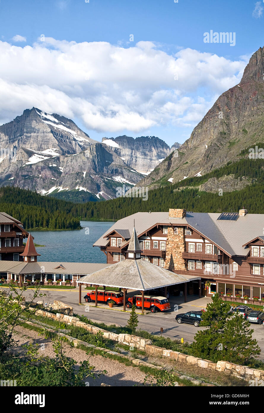 Many Glacier hotel on Swiftcurrent Lake, with historic Red Buses under the port cochere.  The Red Buss are considered the symbol of GNP and are fresh from a full restoration by the Ford Motor Company.  Built between 1936-39, they have tops that roll back Stock Photo