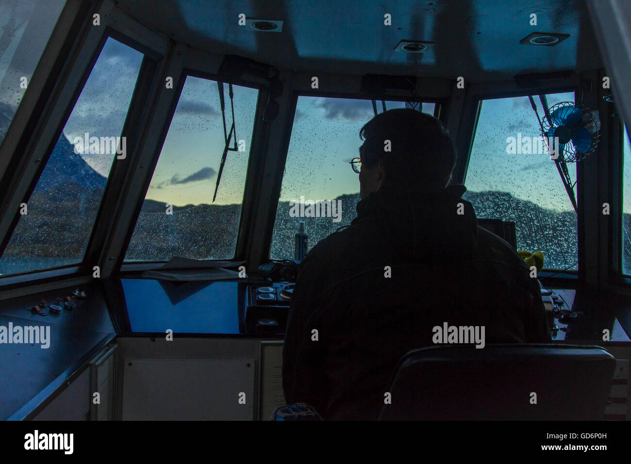 A captain steers the boat into sunset Stock Photo Alamy