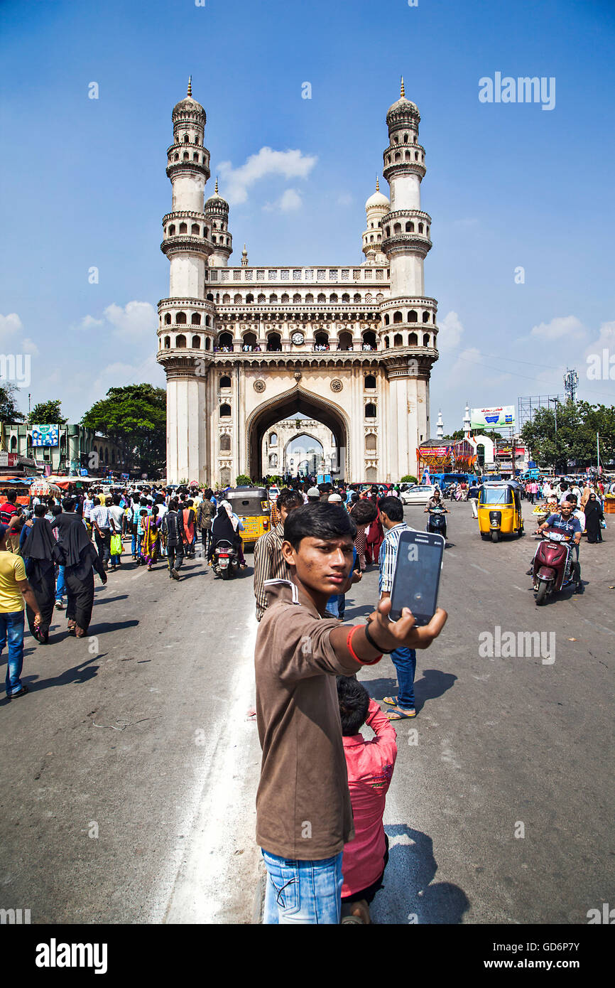 A boy take selfie with Char Minar. Constructed in Islamic architecture using pulverised marble, limestone, mortar and  granite, a square structure of 20 * 20 meter sized Char minar is the most famous Historical site in Hyderabad. The fifth ruler of the Qu Stock Photo