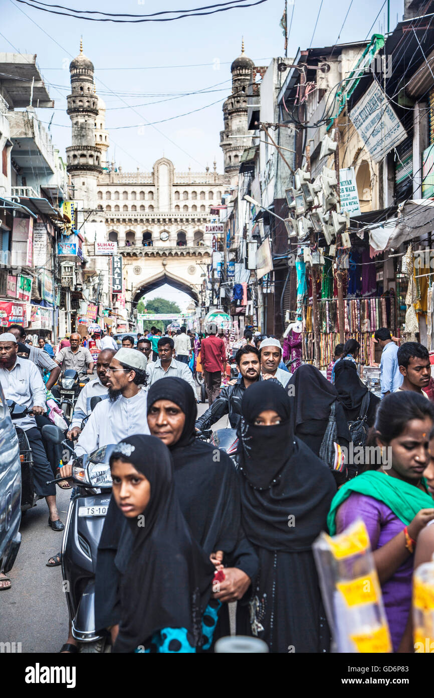 Burkha women walk pass busy streets and market near Char Minar in Hyderabad, India, Stock Photo
