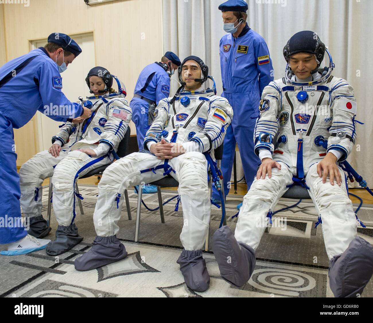 International Space Station Expedition 48 prime crew members have their Russian Sokol launch and entry suits pressure checked before launch at the Baikonur Cosmodrome July 7, 2016 in Kazakhstan. Left to Right: American astronaut Kate Rubens, Russian cosmonaut Anatoly Ivanishin, and Japanese astronaut Takuya Onishi. Stock Photo