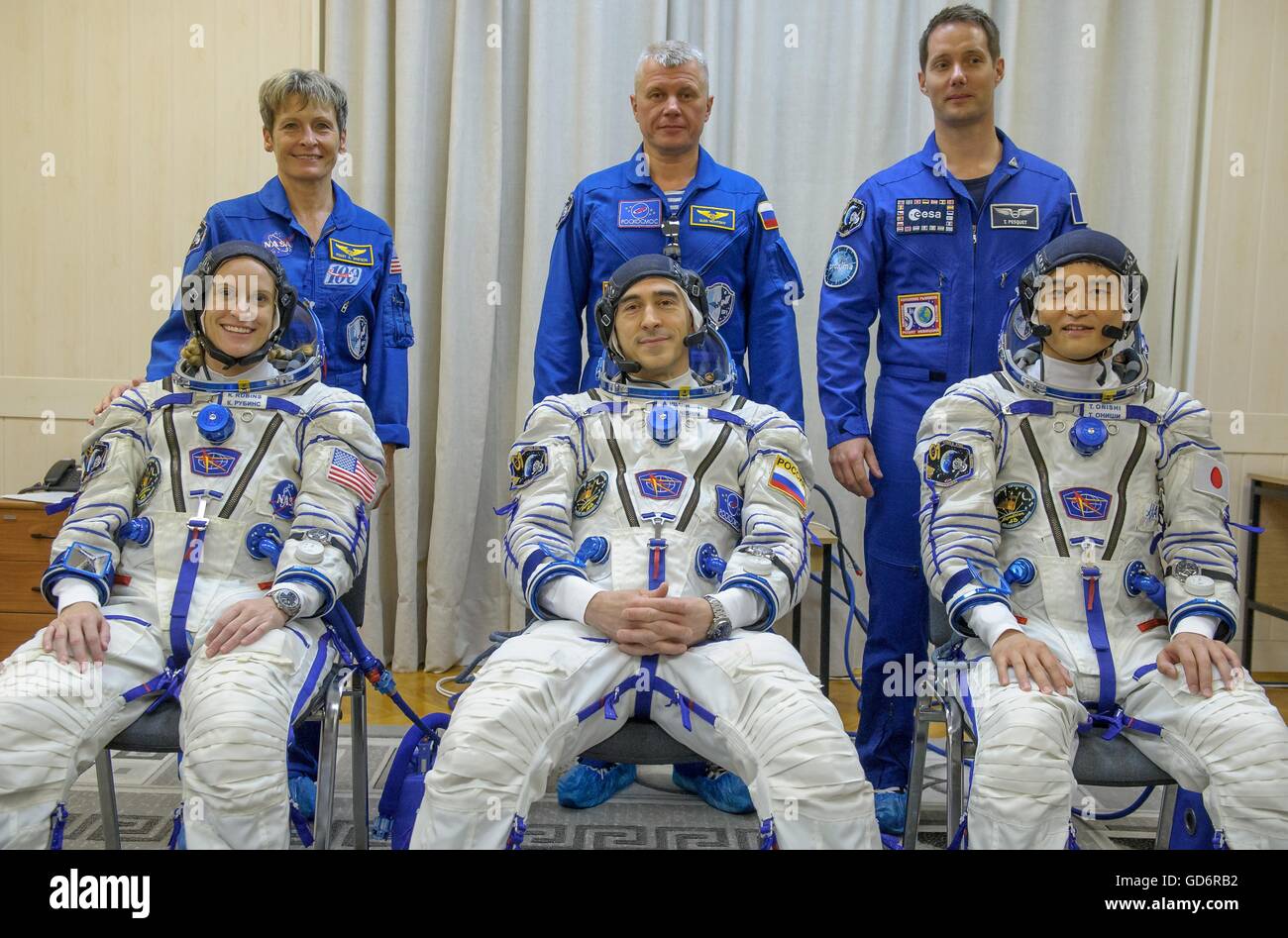 International Space Station Expedition 48 prime crew members wearing Russian Sokol launch and entry suit pose with back up crew before launch at the Baikonur Cosmodrome July 7, 2016 in Kazakhstan. Seated: American astronaut Kate Rubens, Russian cosmonaut Anatoly Ivanishin and Japanese astronaut Takuya Onishi. Standing: American astronaut Peggy Whitson, Russian cosmonaut Oleg Novitskiy, and French astronaut Thomas Pesquet. Stock Photo