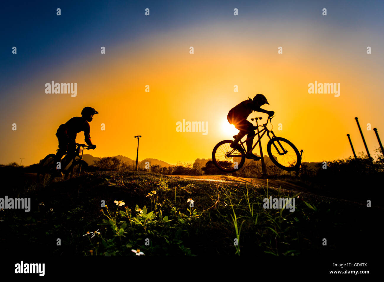 Silhouette Of Stunt Bmx Riders - color tone tuned Stock Photo