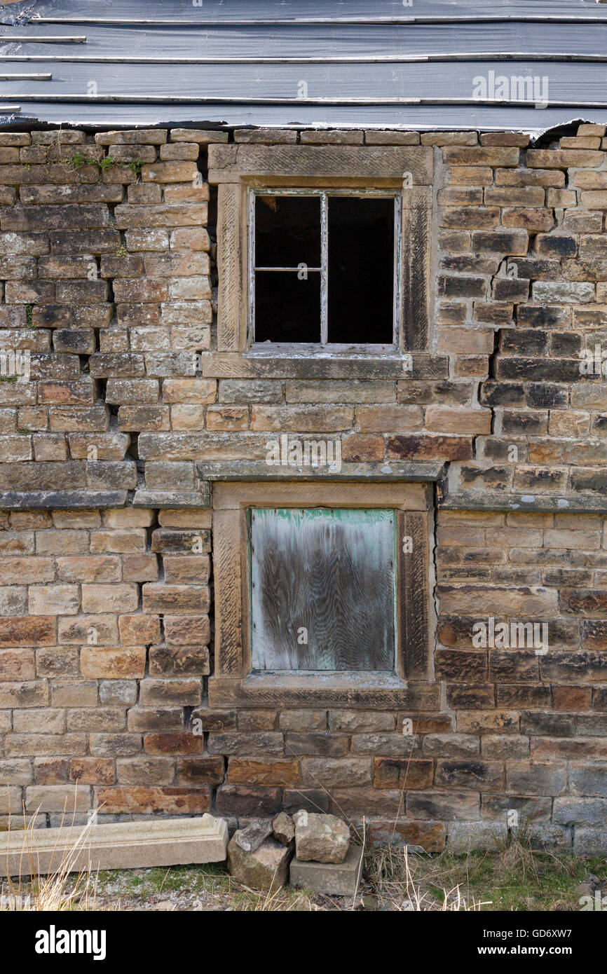 Cracks in a stone wall of a cottage or house that has fallen into disrepair, England, UK Stock Photo