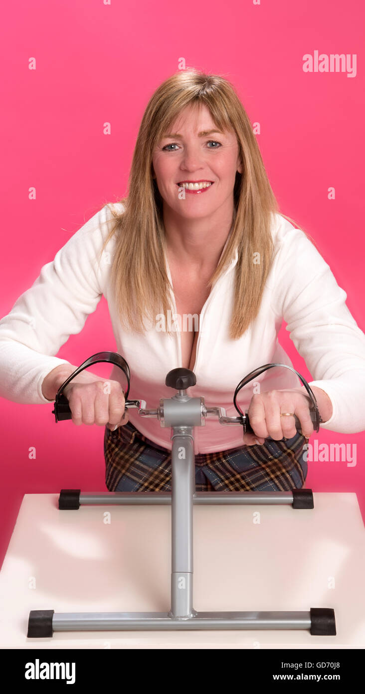 Woman getting arm and wrist exercise with tabletop machine Stock Photo