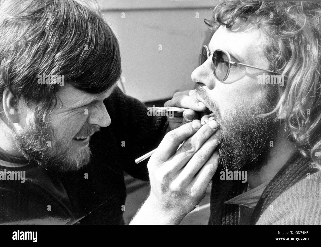 AJAX NEWS PHOTOS. 30TH APRIL, 1974. PORTSMOUTH, ENGLAND. - WHITBREAD ROUND THE WORLD RACE - (L-R) GERT FINDEL OF DUSSELDORF, STUDENT DENTIST ABOARD GERMAN YACHT PETER VON DANZIG, DEMONSTRATES HOW HE KEPT TEETH OF YACHT'S 9 CREW IN GOOD SHAPE DURING LAST LEG OF RACE. GUINEA PIG IS CREWMAN TOMAS REUTHER, MEDICAL STUDENT. PHOTO:JONATHAN EASTLAND/AJAX  REF:PEO VON DANZIG WRWR 1974 Stock Photo