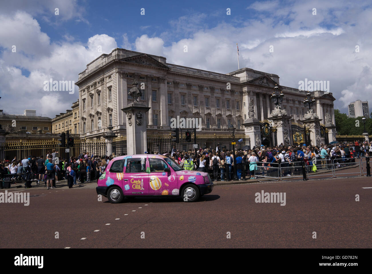 Pink Taxi in the foreground of Buckingham Palace during Changing of the Guard. Stock Photo