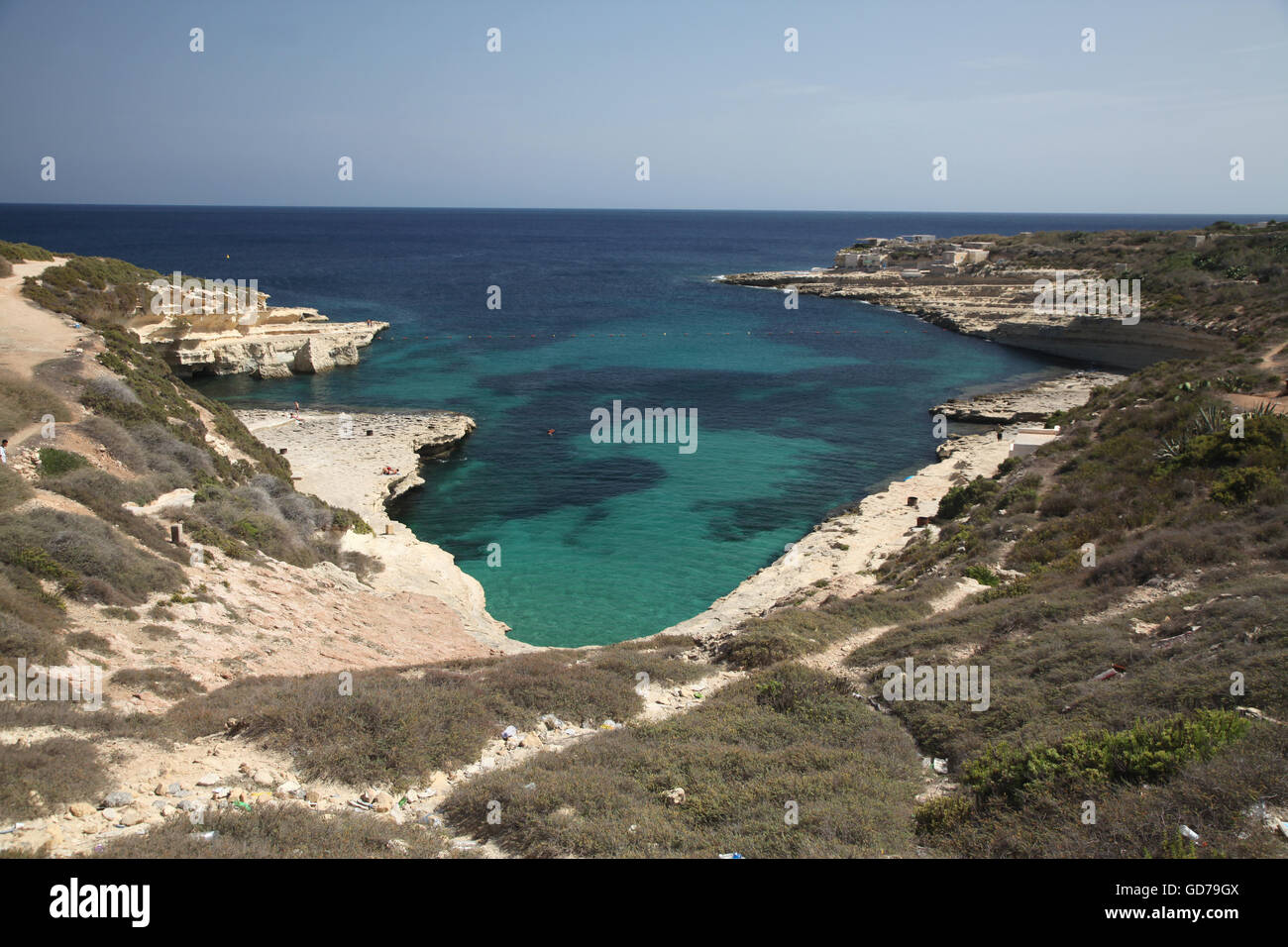 View down onto the small and secluded Delimara pool in the south of Malta, showing the rocky surrounding coast and ocean. Stock Photo