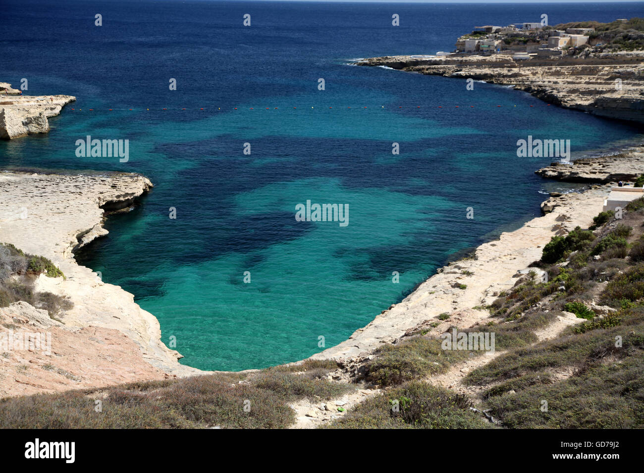 A favourite bathing spot in Malta at Delimara looking down on the bright blue sea Stock Photo
