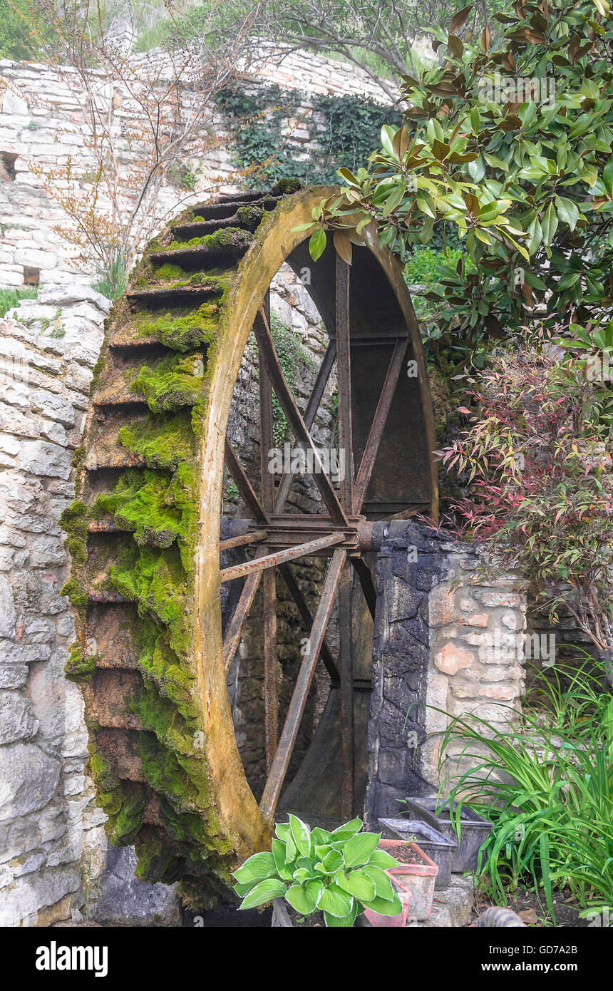 Wheel of an old water mill overgrown with with moss. Stock Photo