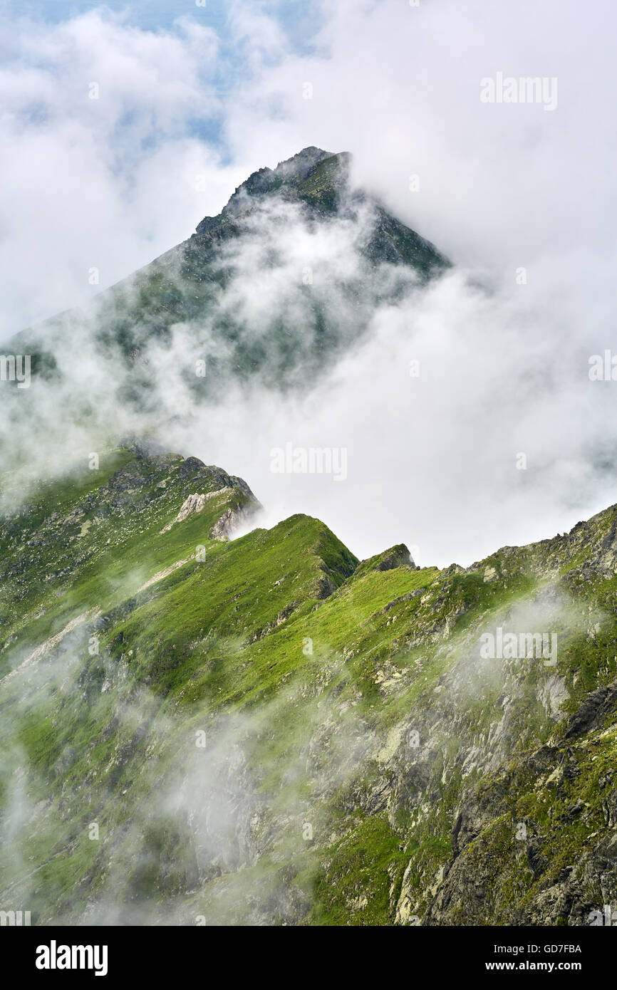 Landscape with rocky mountains seen through the mist and clouds Stock ...