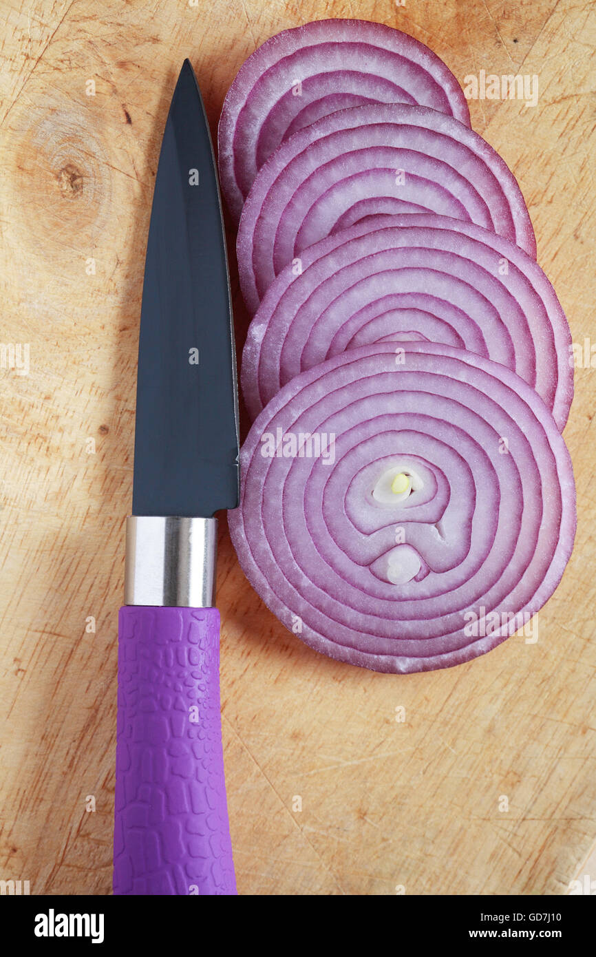 Red sliced onion near knife on wooden cutting board Stock Photo - Alamy