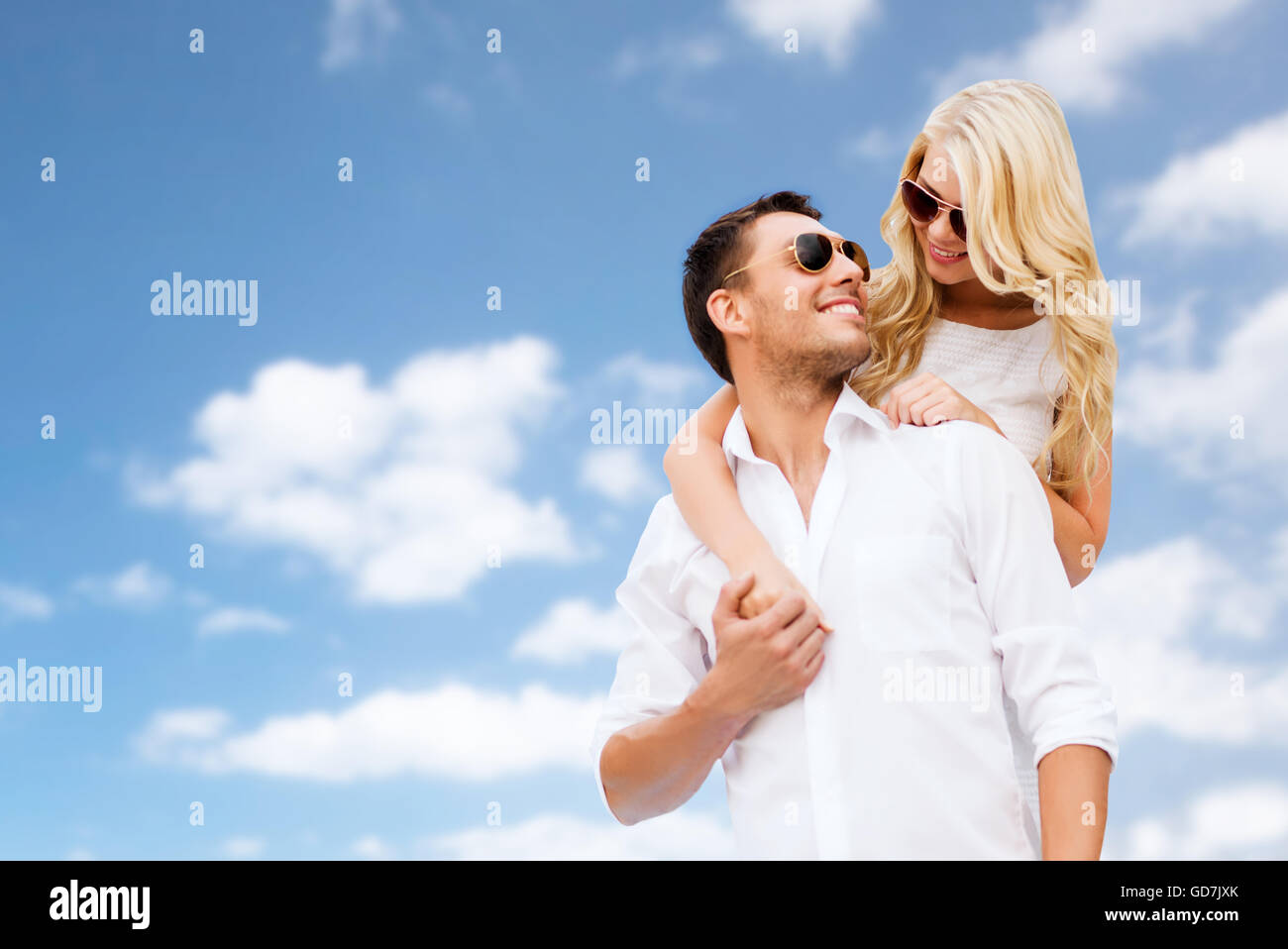 happy couple in sunglasses over blue sky Stock Photo - Alamy