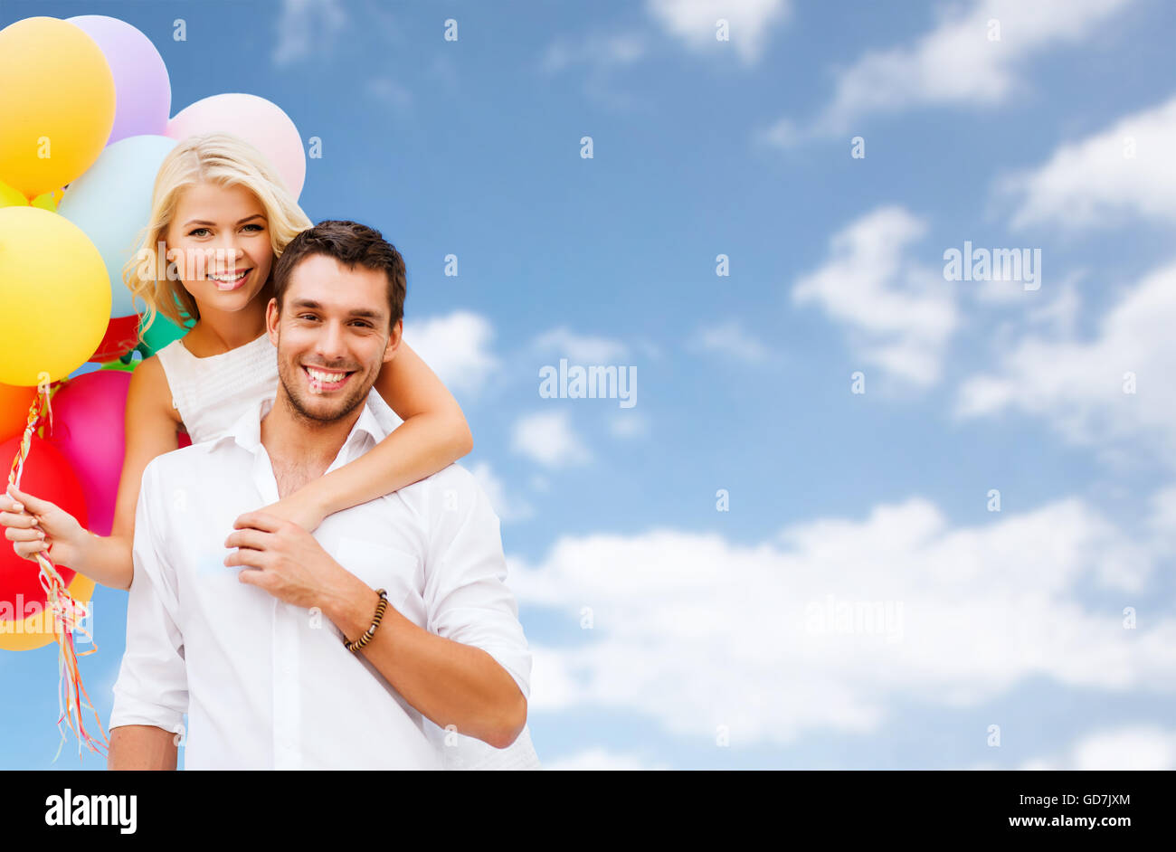 happy couple with balloons over blue sky Stock Photo - Alamy