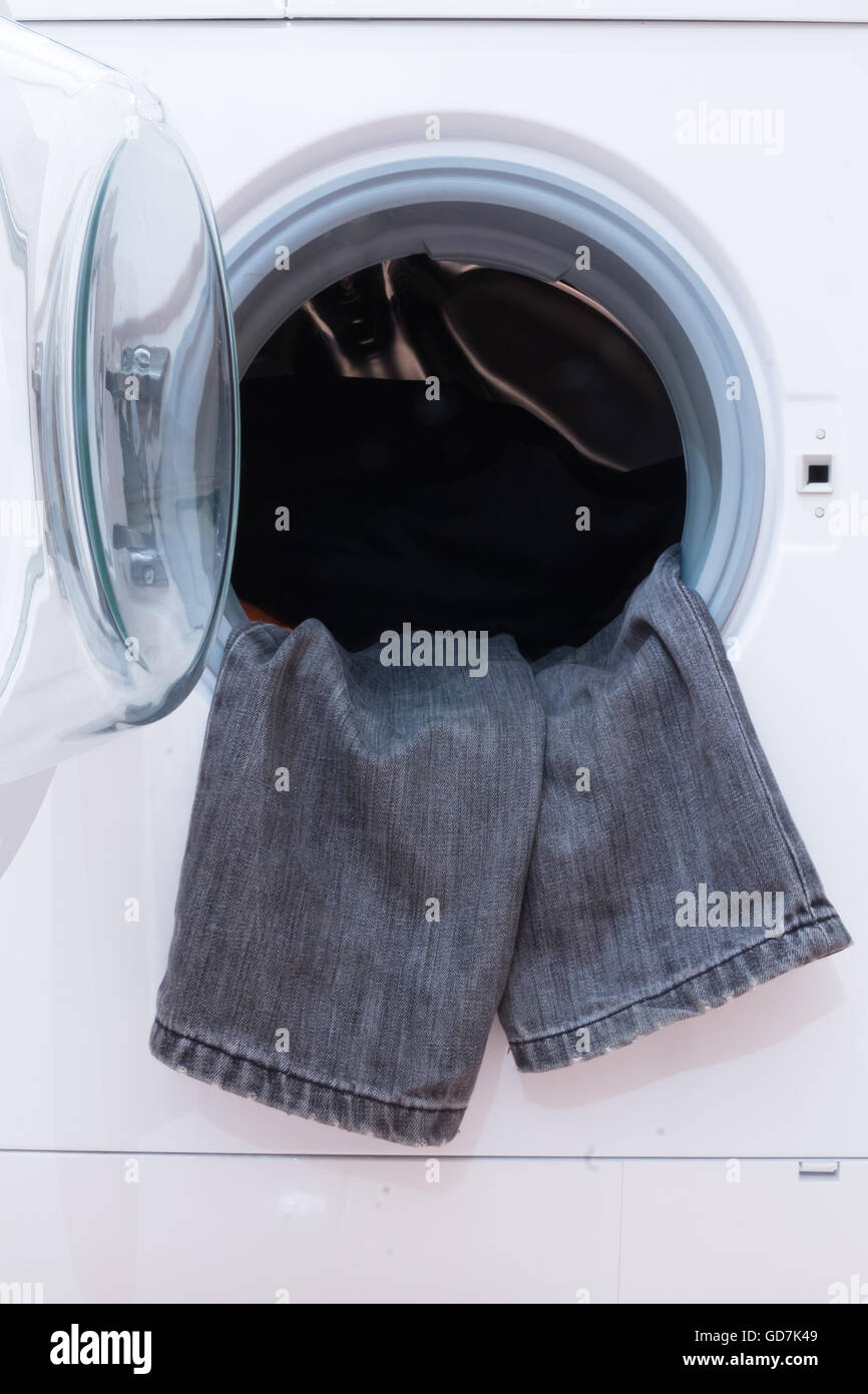 A close up of a washing machine loaded with clothes. Household ...