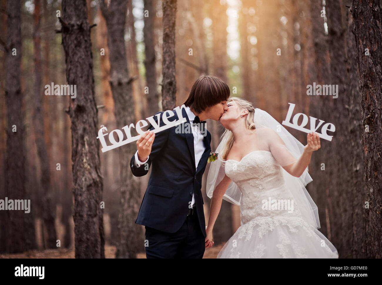 groom kissing the bride at a wedding in the autumn forest and ho Stock ...