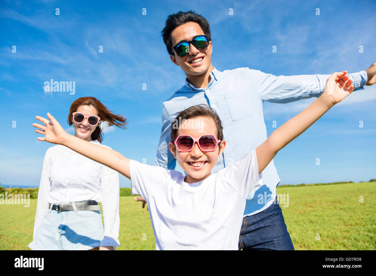 Happy young family playing on the grass Stock Photo