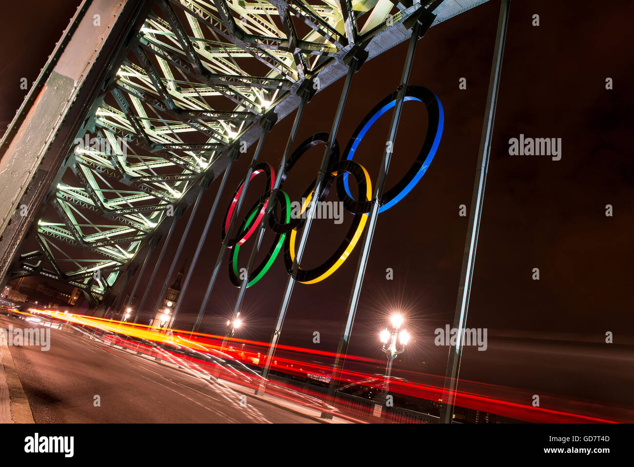 The Olympic Rings hang on the Tyne Bridge in Newcastle during the London Olympics 2012. They are lite up at night as traffic passes by. Stock Photo