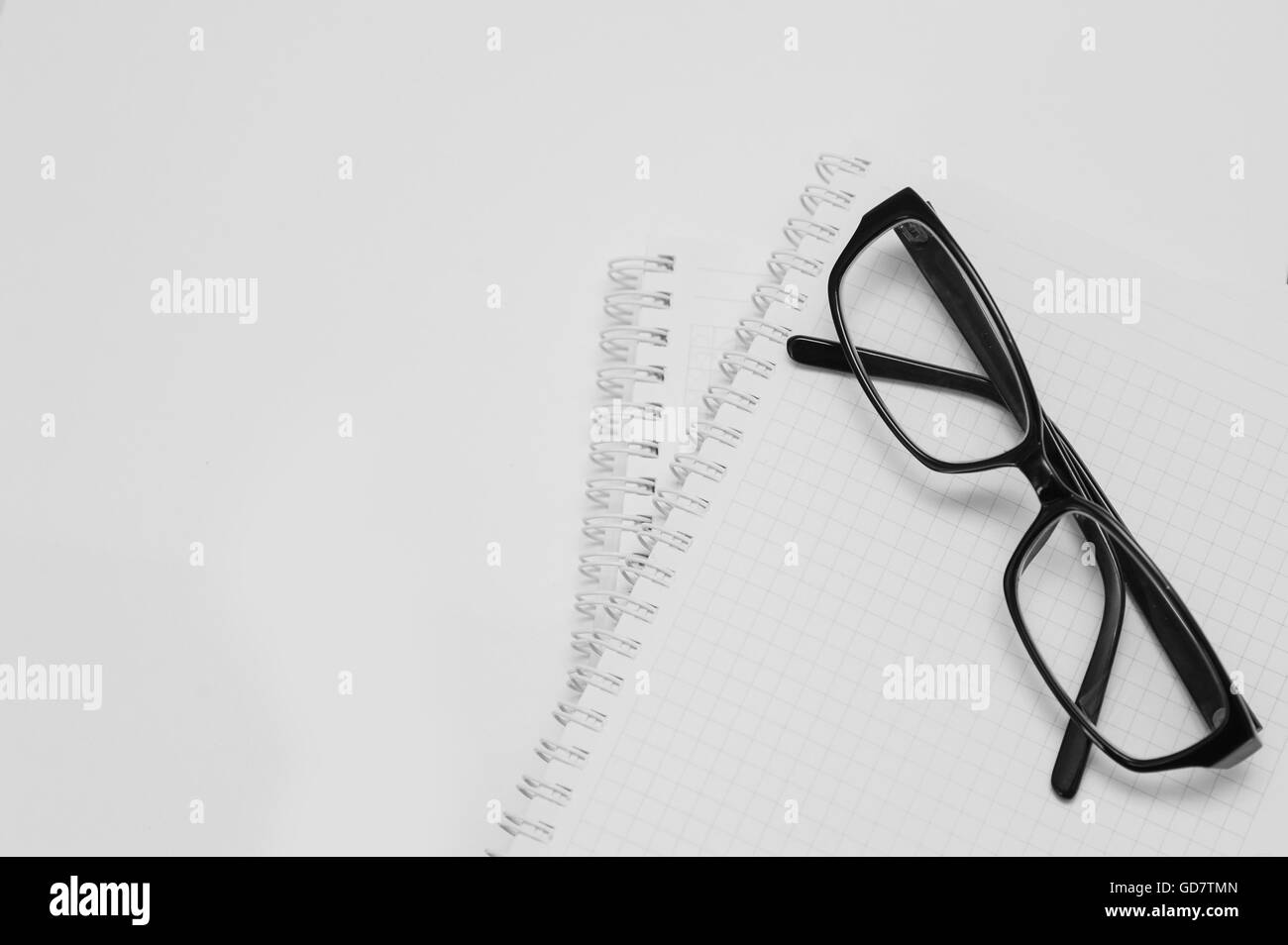 black plastic glasses on the opened notepad Stock Photo