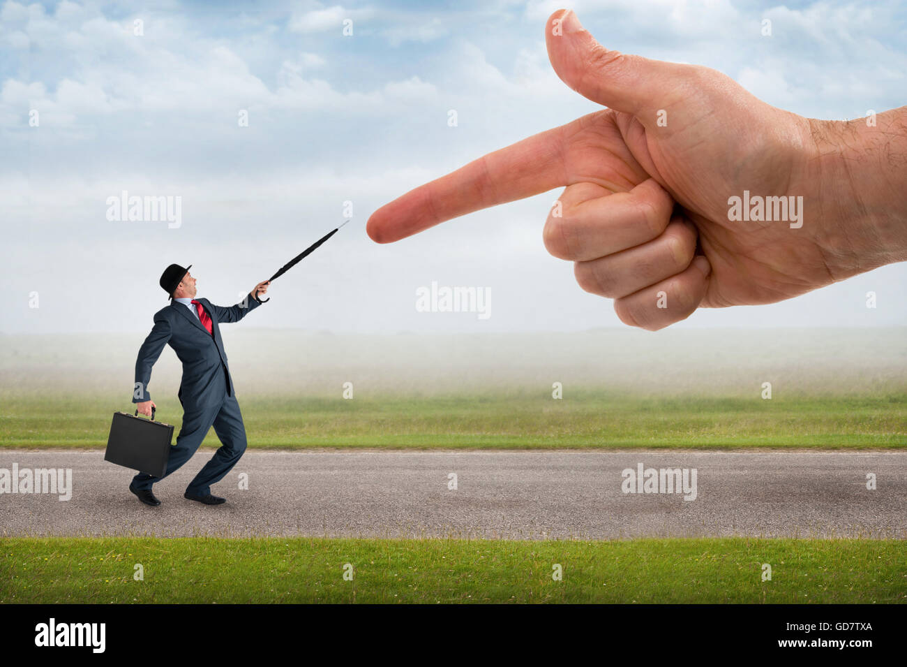 business accusation concept giant finger pointing aggressively at a defensive businessman Stock Photo