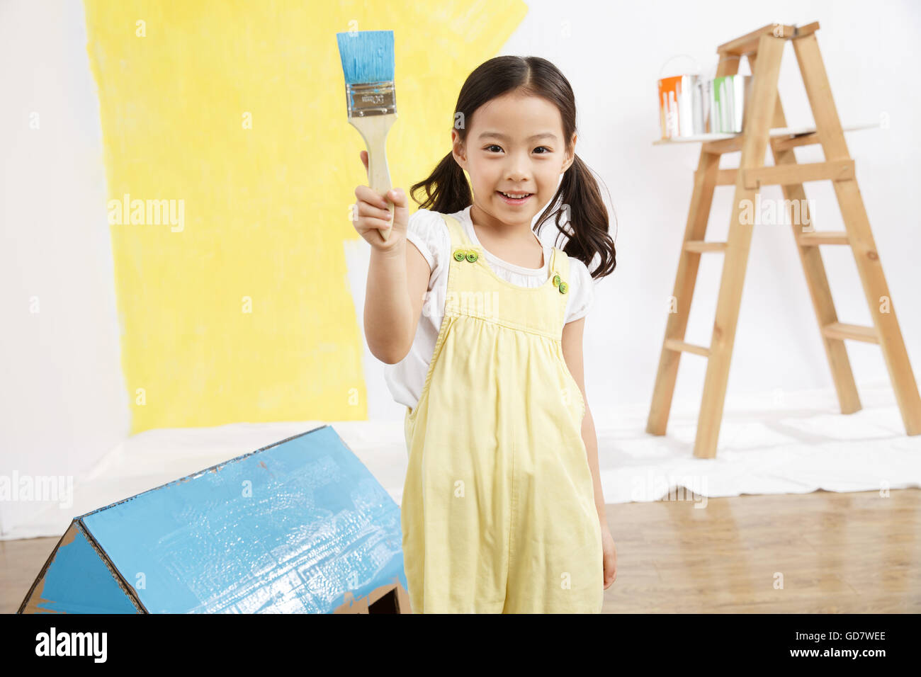 Cute little girl with a paint brush Stock Photo - Alamy