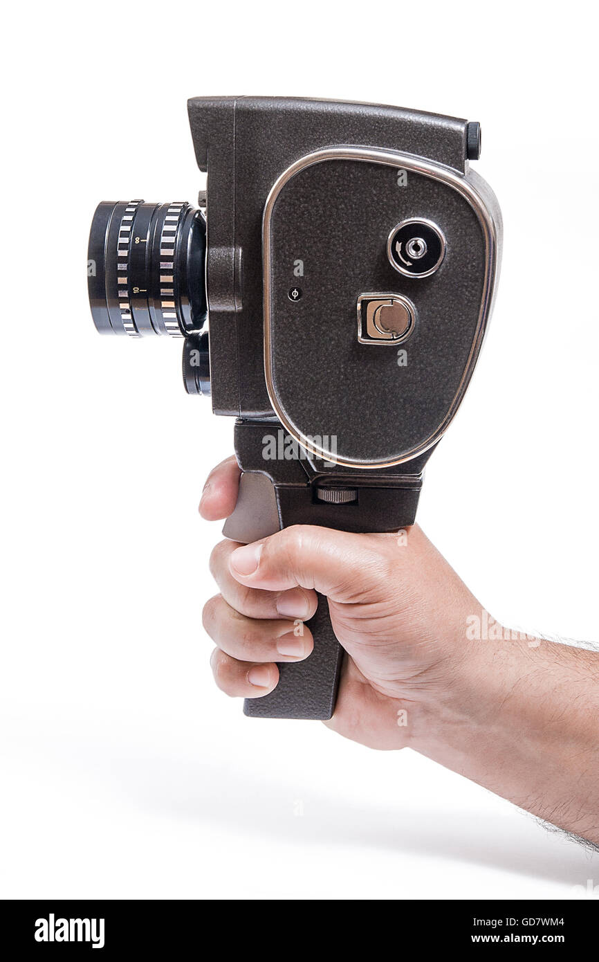 Old movie camera with lens in hand isolated on a white background. With