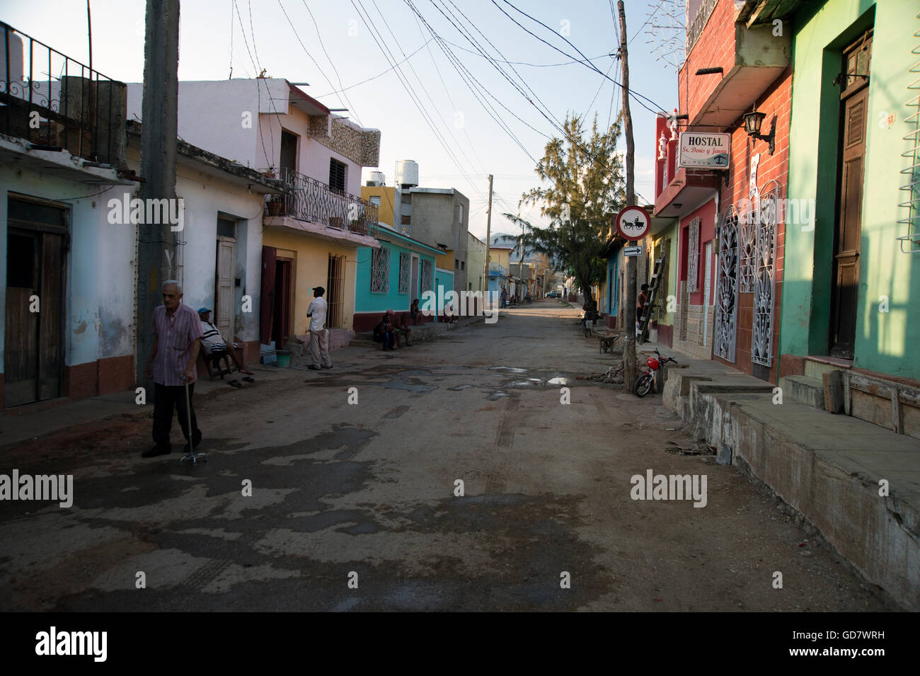 Cuban men hang around a neglected street of traditional houses in a rundown area of Trinidad Cuba Stock Photo