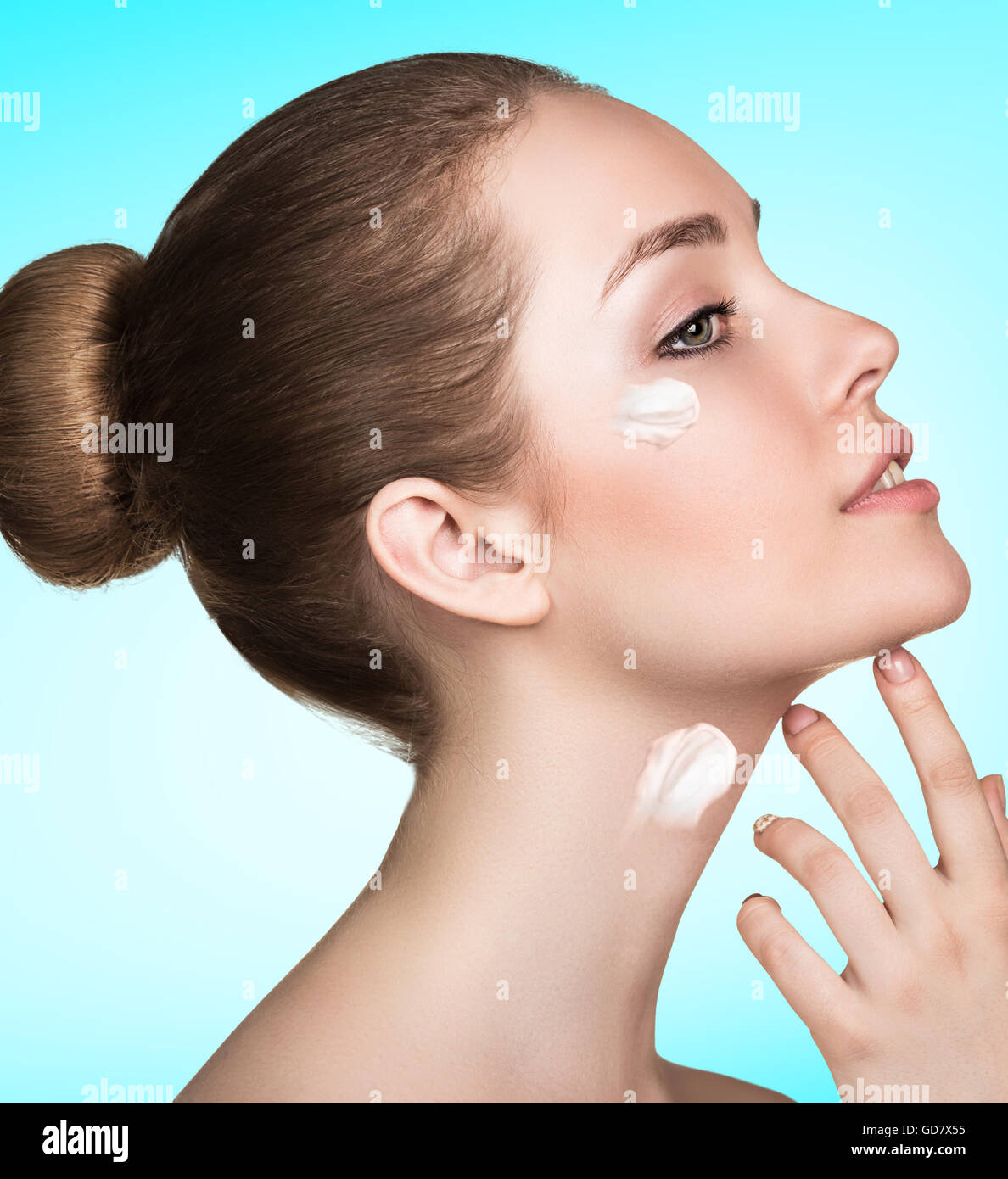 Beautiful model applying cream on face Stock Photo