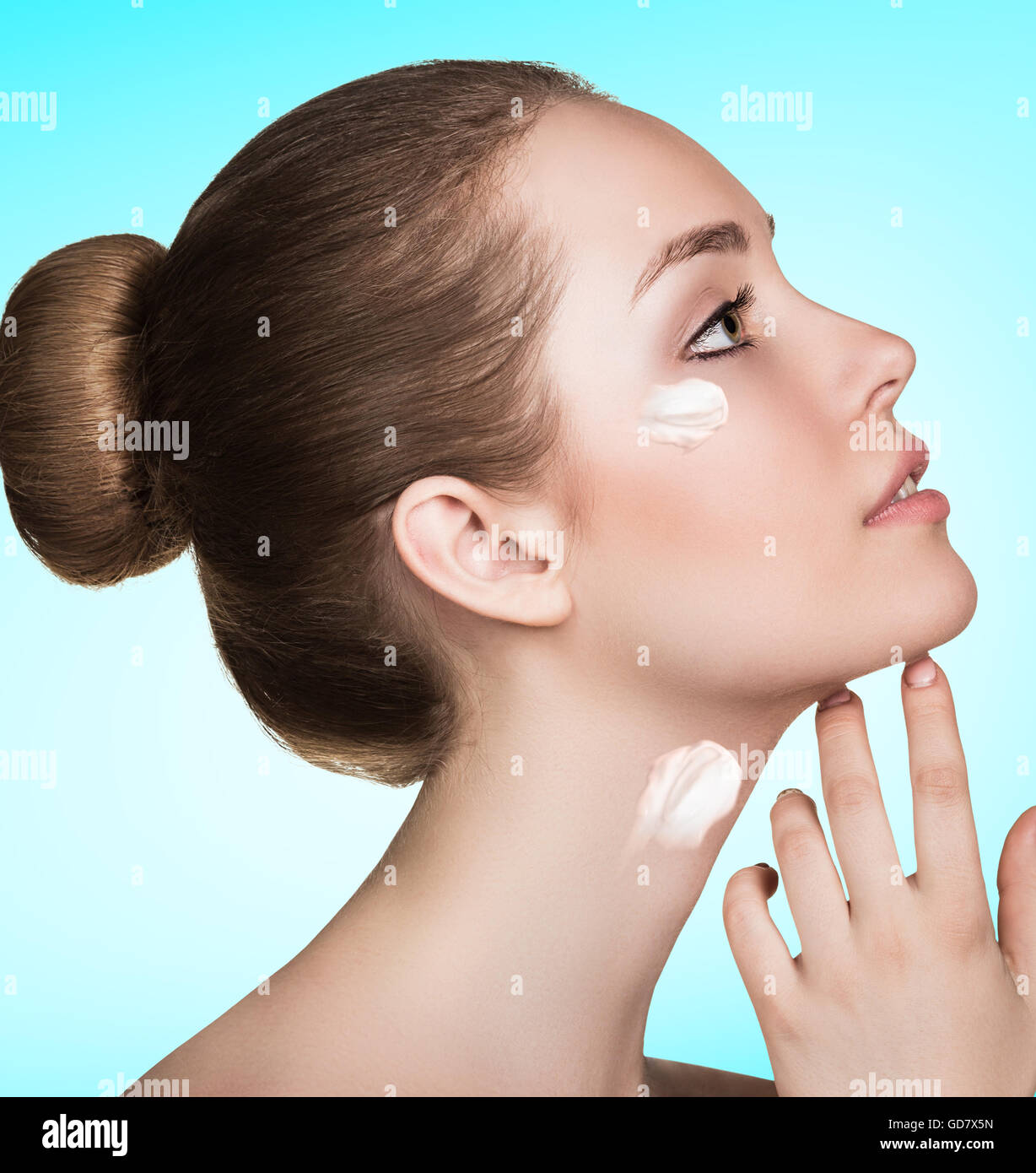 Beautiful model applying cream on face Stock Photo