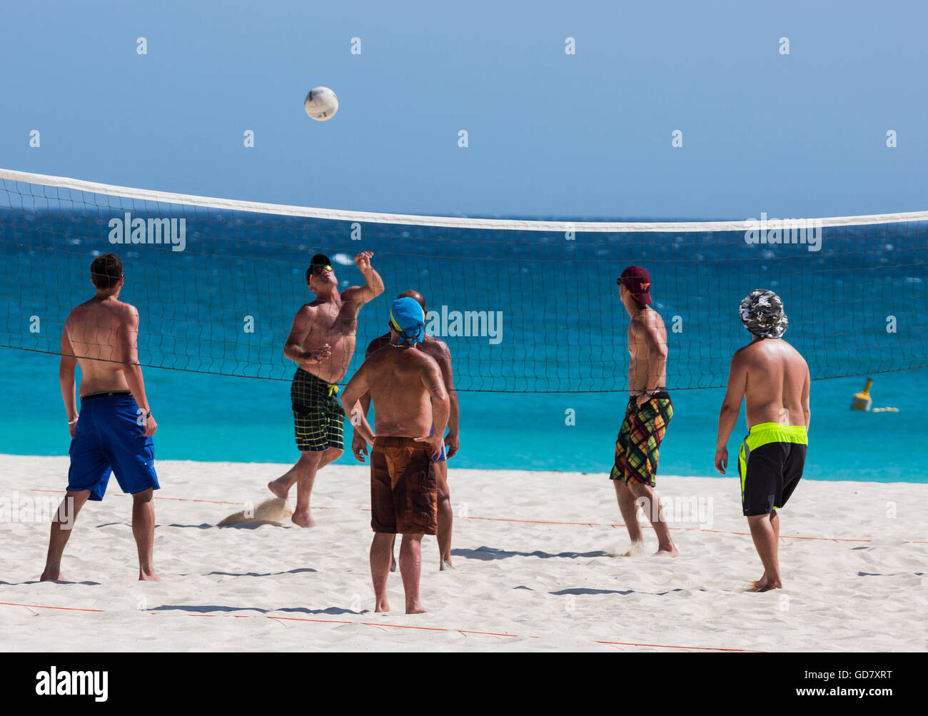 Men playing beach volleyball at Hadicurari Beach, Aruba. Stock Photo