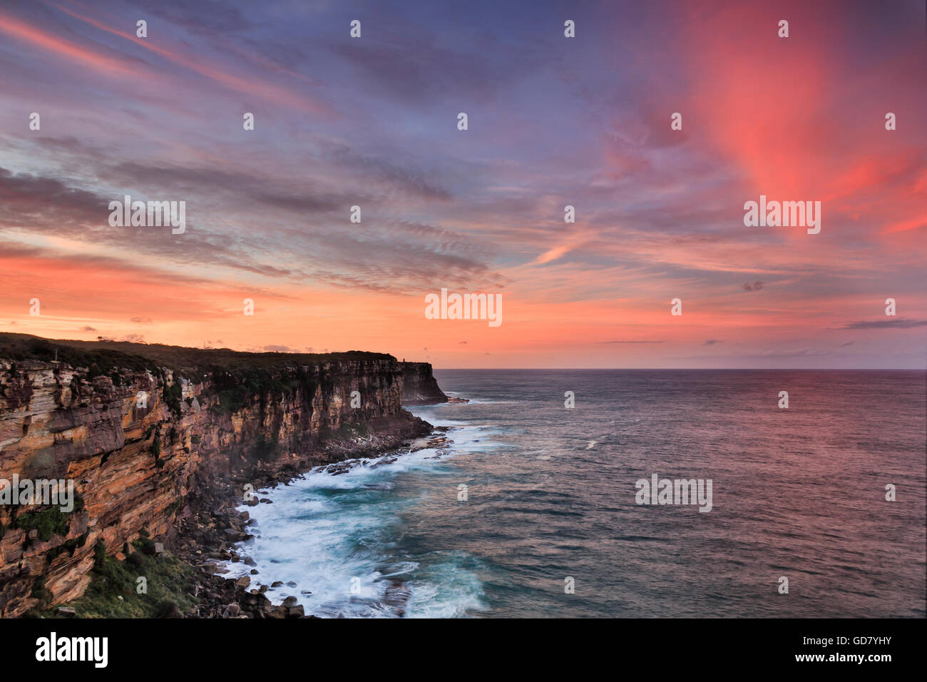 Steep rocky cliffs of Australia continental plato facing Pacific ocean at sunset. North HEad of Entrance to SYdney Harbour Stock Photo