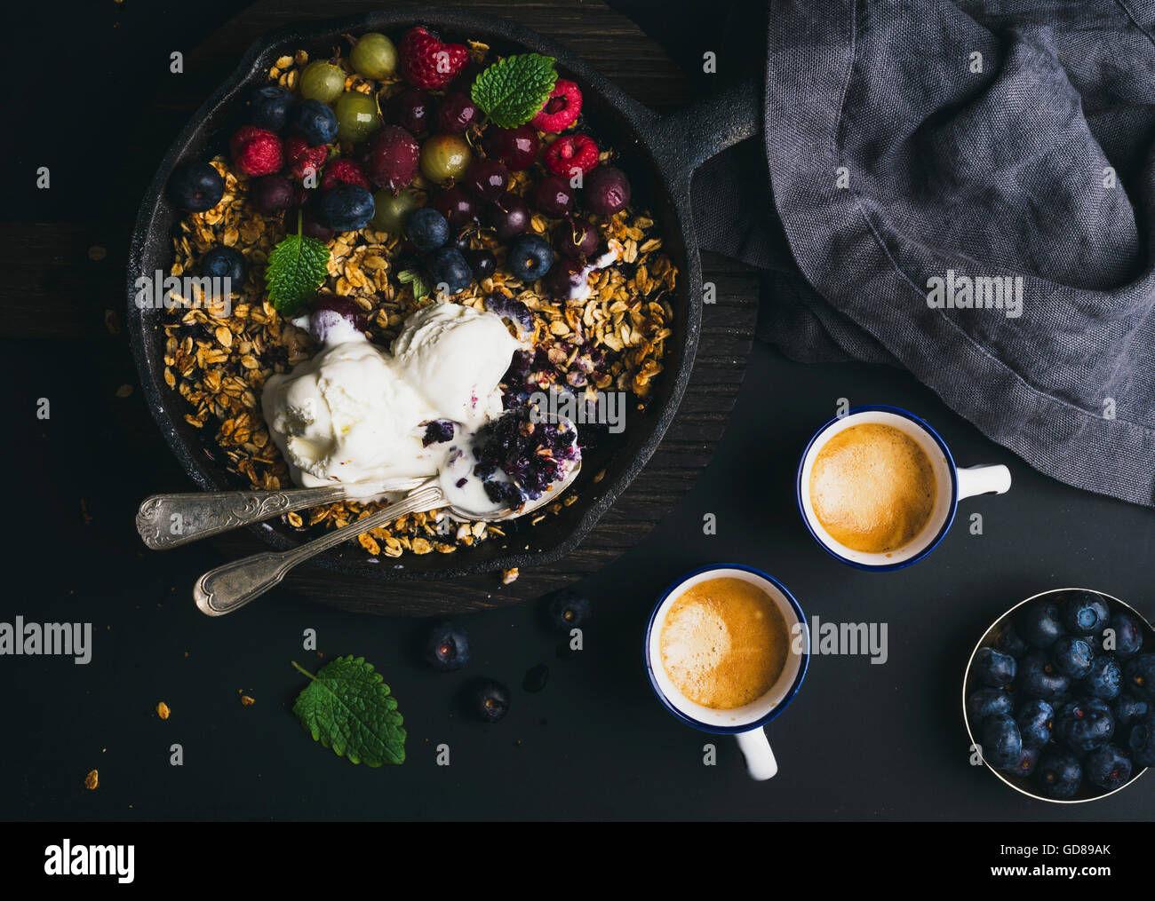 Healthy breakfast concept. Oat granola crumble with fresh berries, seeds, icecream and mint in