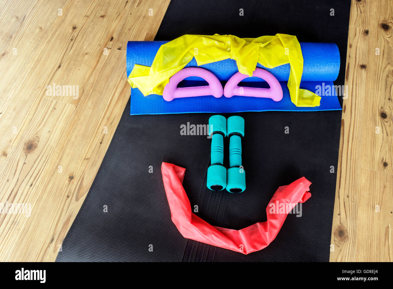 Resistance Bands And Hand Weights On Yoga Mats Set Out In A Smiley