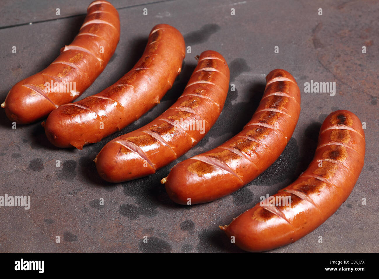 Grilling sausages on wood burning stove Stock Photo Alamy