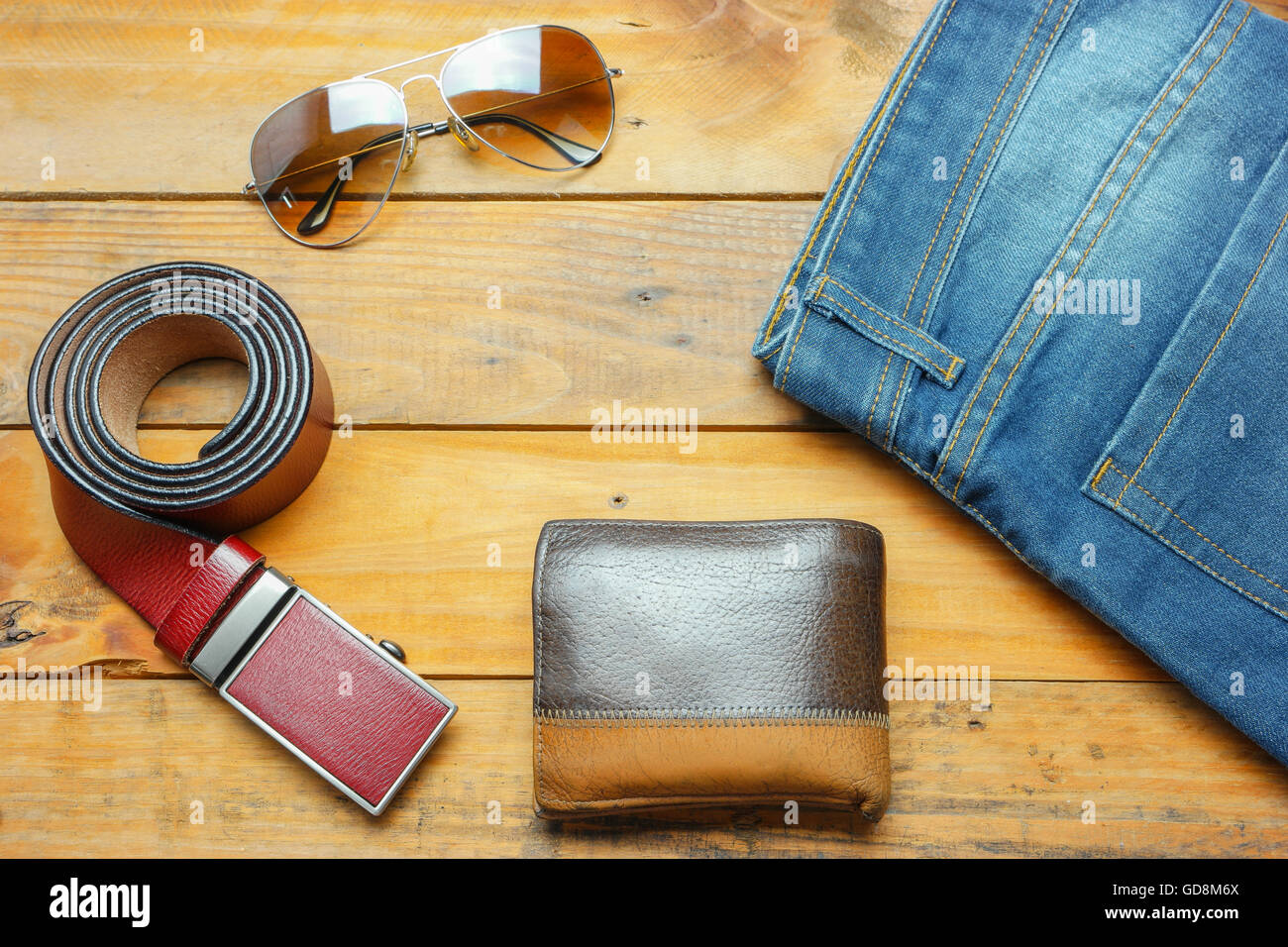 https://c8.alamy.com/comp/GD8M6X/jeans-sunglasses-and-leather-belt-wallet-on-the-wooden-vintage-with-GD8M6X.jpg