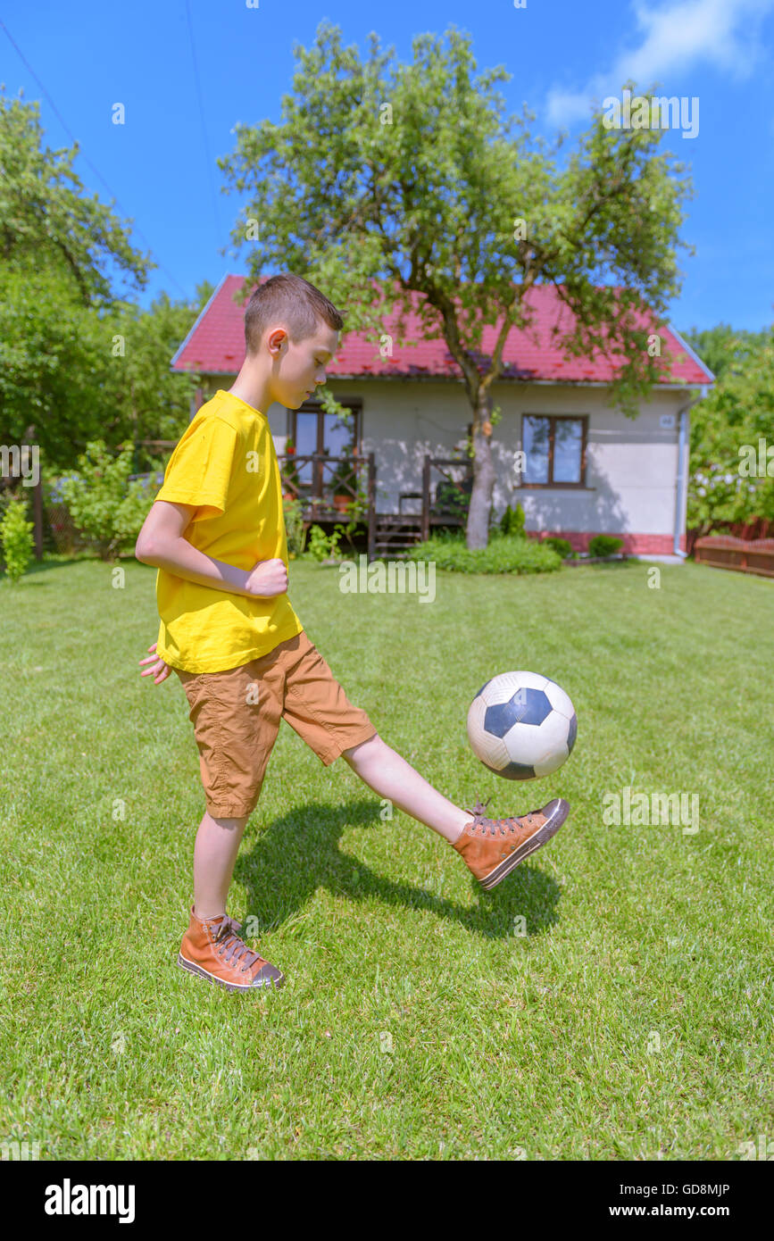 Boy with ball on green lawn. Summer time! Stock Photo