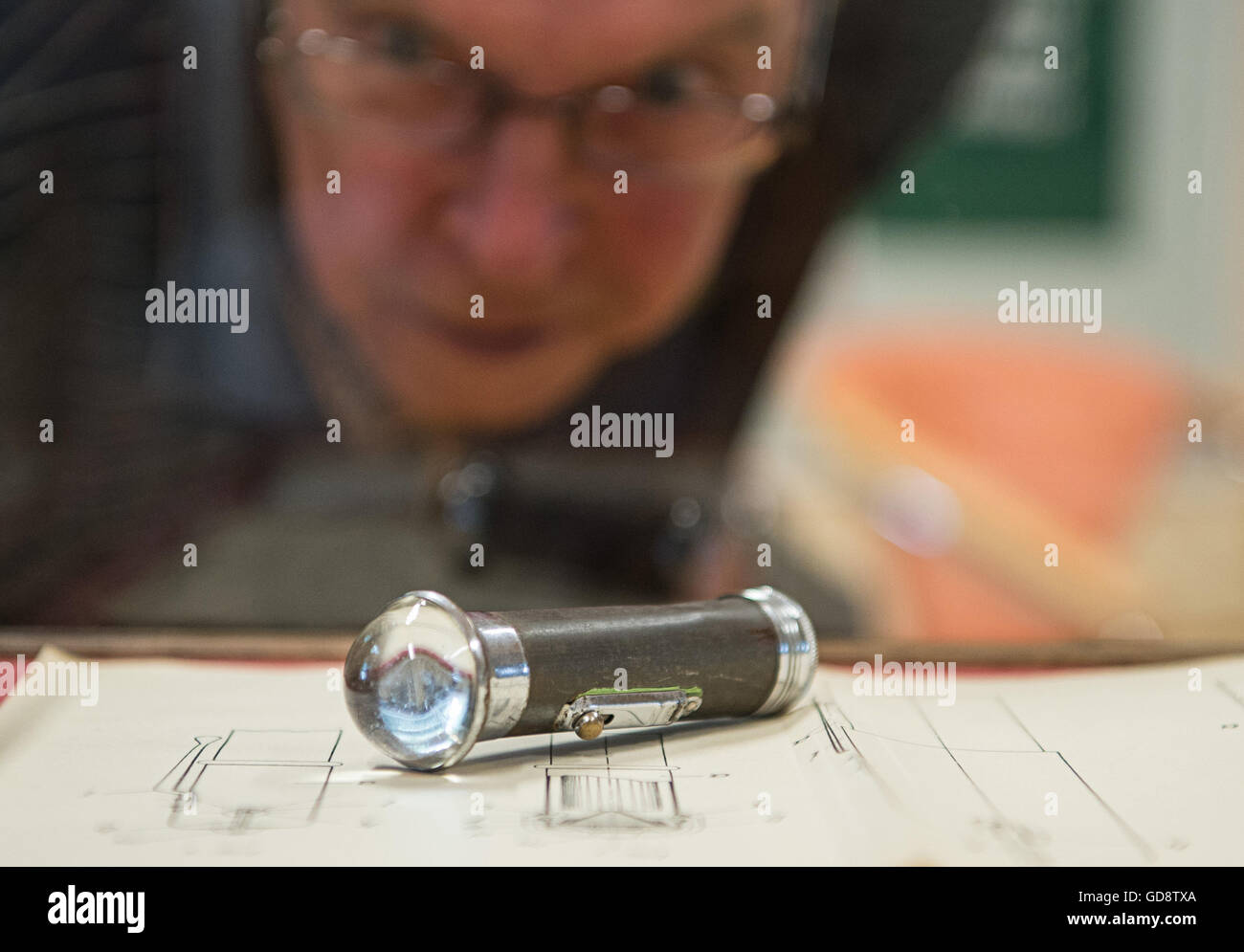 Berlin, Germany. 13th July, 2016. A visitor looks at a historical flashlight during the opening of the Daimon Museum in Berlin, Germany, 13 July 2016. The museum is dedicated to the inventor of flashlights, Paul Schmidt, who also founded the company Daimon. Photo: Wolfram Kastl/dpa/Alamy Live News Stock Photo