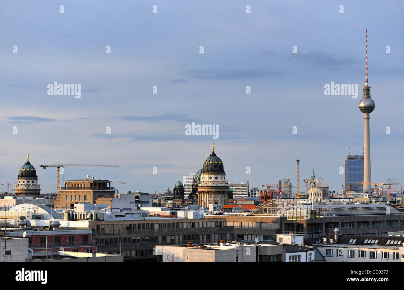 Berlin, Germany. 12th July, 2016. View from the EWerk in Berlin-Mitte across the rooftops of the capital with the French cathedral (l-r), German cathedral (Berlin cathedral behind it), the cupola under construction of the city castle, the hotel Park Inn and the TV Tower on Alexanderplatz in Berlin, Germany, 12 July 2016. Photo: Jens Kalaene/dpa/Alamy Live News Stock Photo
