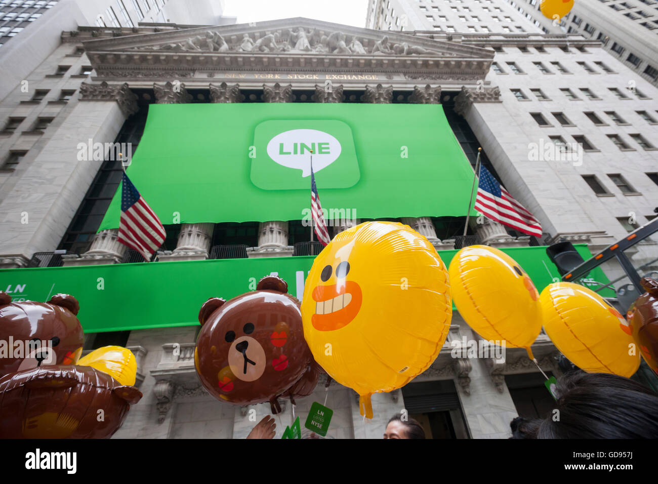 New York, USA. 14th July, 2016. Hordes of visitors clammer for free balloons with faces representing Line 'stickers' in front of the New York Stock Exchange decorated for the Japanese messaging company Line's initial public offering on Thursday, July 14, 2016. Line Corp., a popular messaging app in Japan is owned by South Korean Naver Corp. Line has 218 million active users monthly, with Japan, Taiwan and Indonesia accounting for two-thirds of them.  Credit:  Richard Levine/Alamy Live News Stock Photo