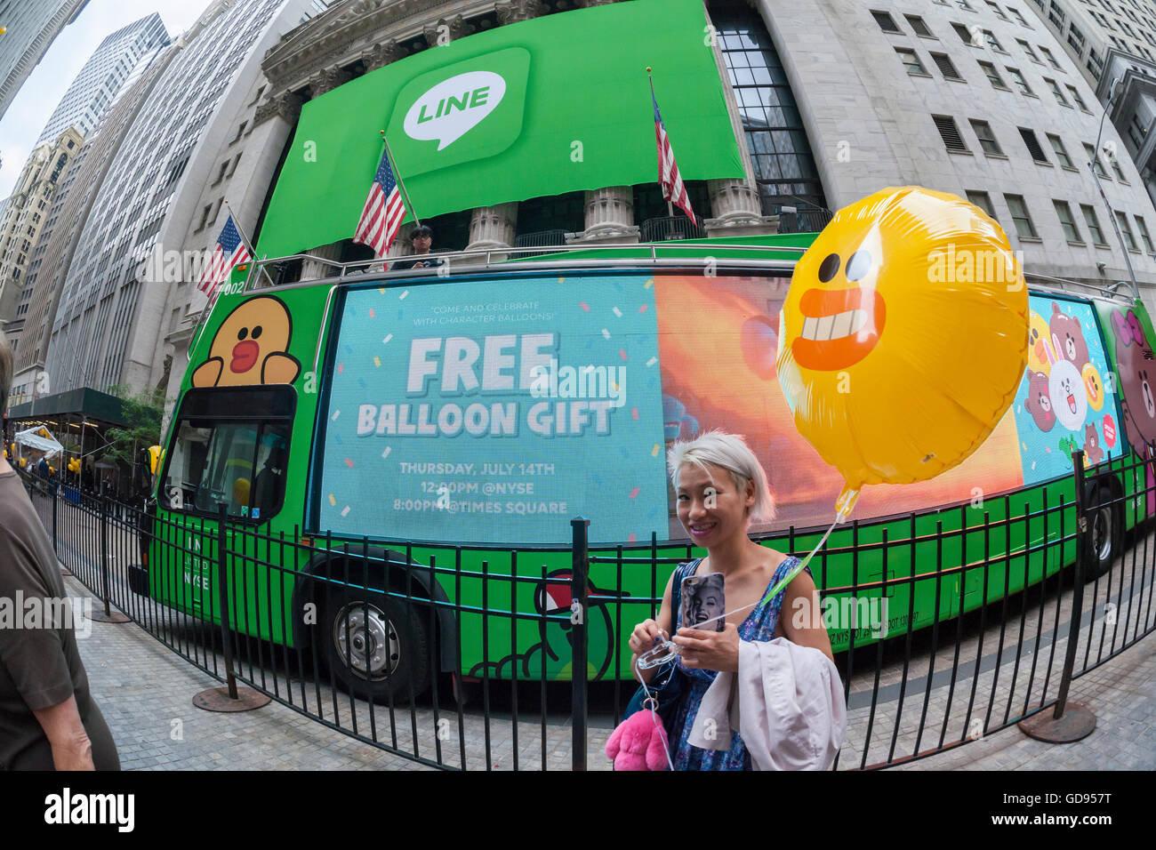 New York, USA. 14th July, 2016. Hordes of visitors clammer for free balloons with faces representing Line 'stickers' in front of the New York Stock Exchange decorated for the Japanese messaging company Line's initial public offering on Thursday, July 14, 2016. Line Corp., a popular messaging app in Japan is owned by South Korean Naver Corp. Line has 218 million active users monthly, with Japan, Taiwan and Indonesia accounting for two-thirds of them.  Credit:  Richard Levine/Alamy Live News Stock Photo