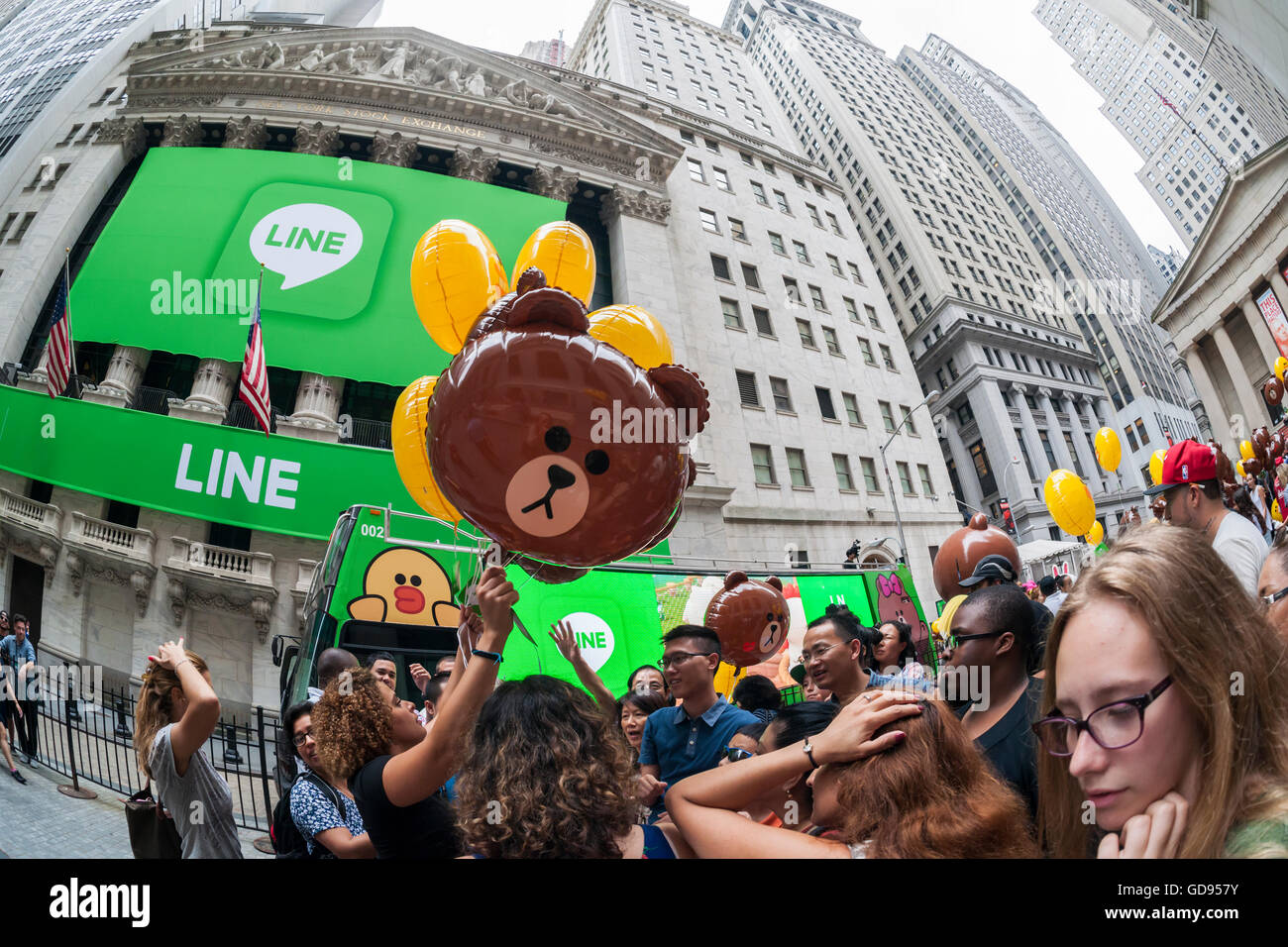 New York, USA. 14th July, 2016. Hordes of visitors clammer for free balloons with faces representing Line 'stickers' in front of the New York Stock Exchange decorated for the Japanese messaging company Line's initial public offering on Thursday, July 14, 2016. Line Corp., a popular messaging app in Japan is owned by South Korean Naver Corp. Line has 218 million active users monthly, with Japan, Taiwan and Indonesia accounting for two-thirds of them.  Credit:  Richard Levine/Alamy Live News Stock Photo
