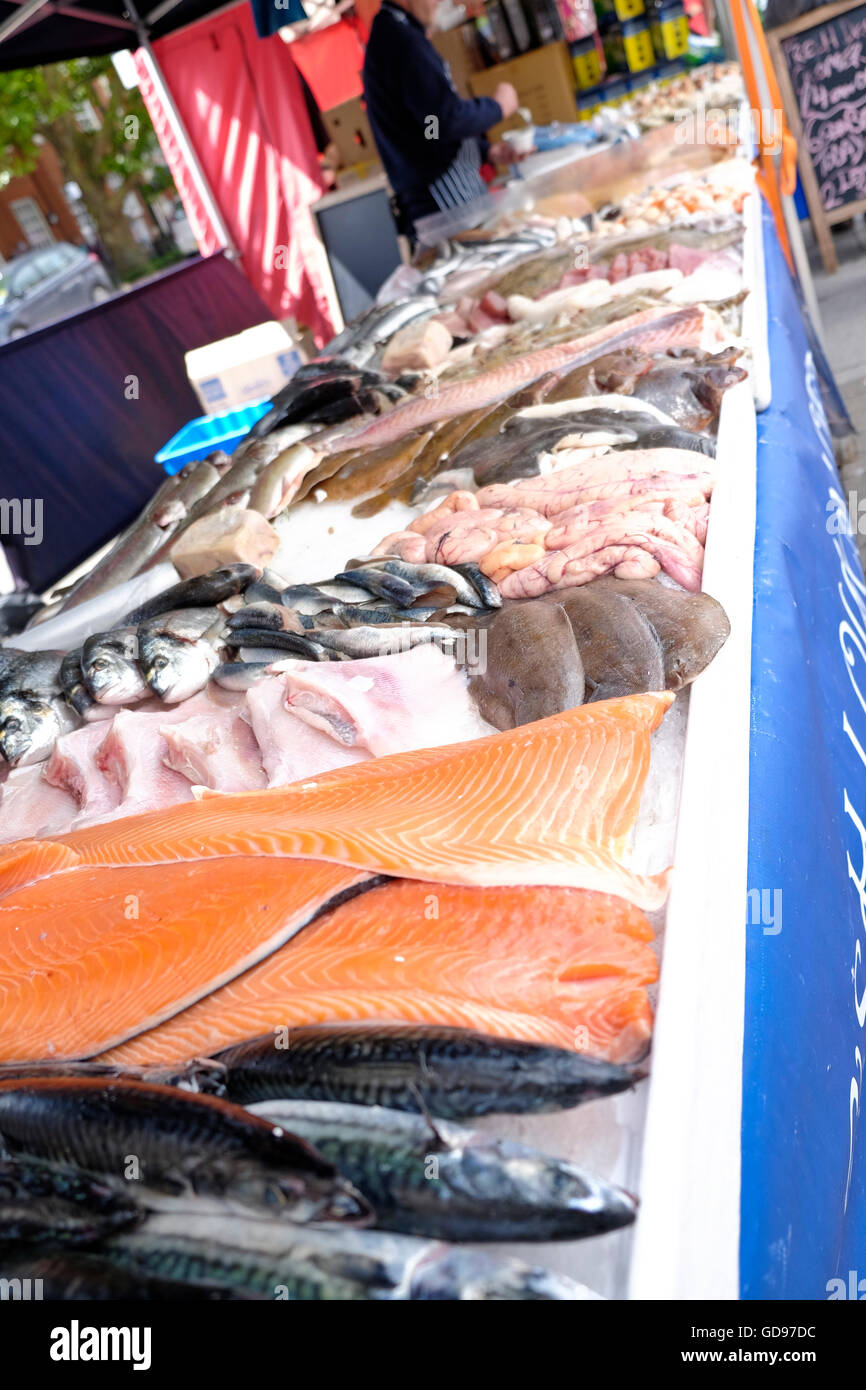 A fishmonger sells fresh fish from a stall set out on the High Street of Brentwood Essex Stock