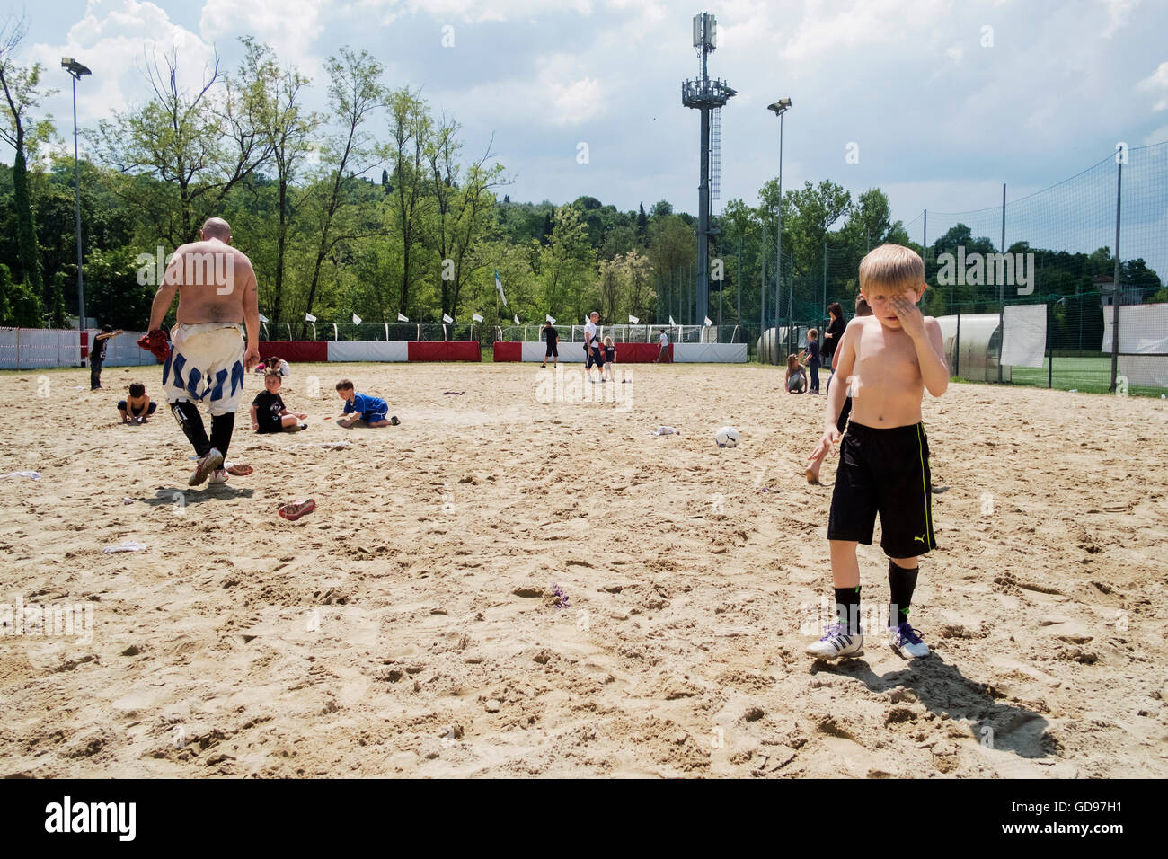 Kid playing in the sand during a Florentine soccer training in Florence Stock Photo