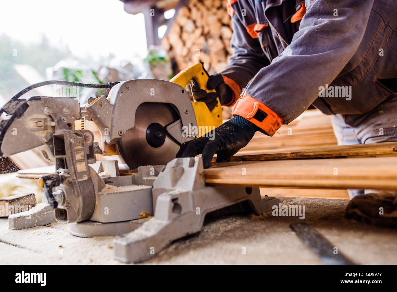 Carpenter working. Man cutting plank by circular saw Stock Photo - Alamy
