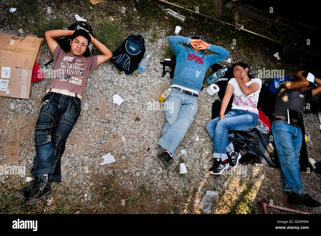Central American immigrants sleep under the stopped cargo train on a train station in Arriaga, Mexico. Stock Photo