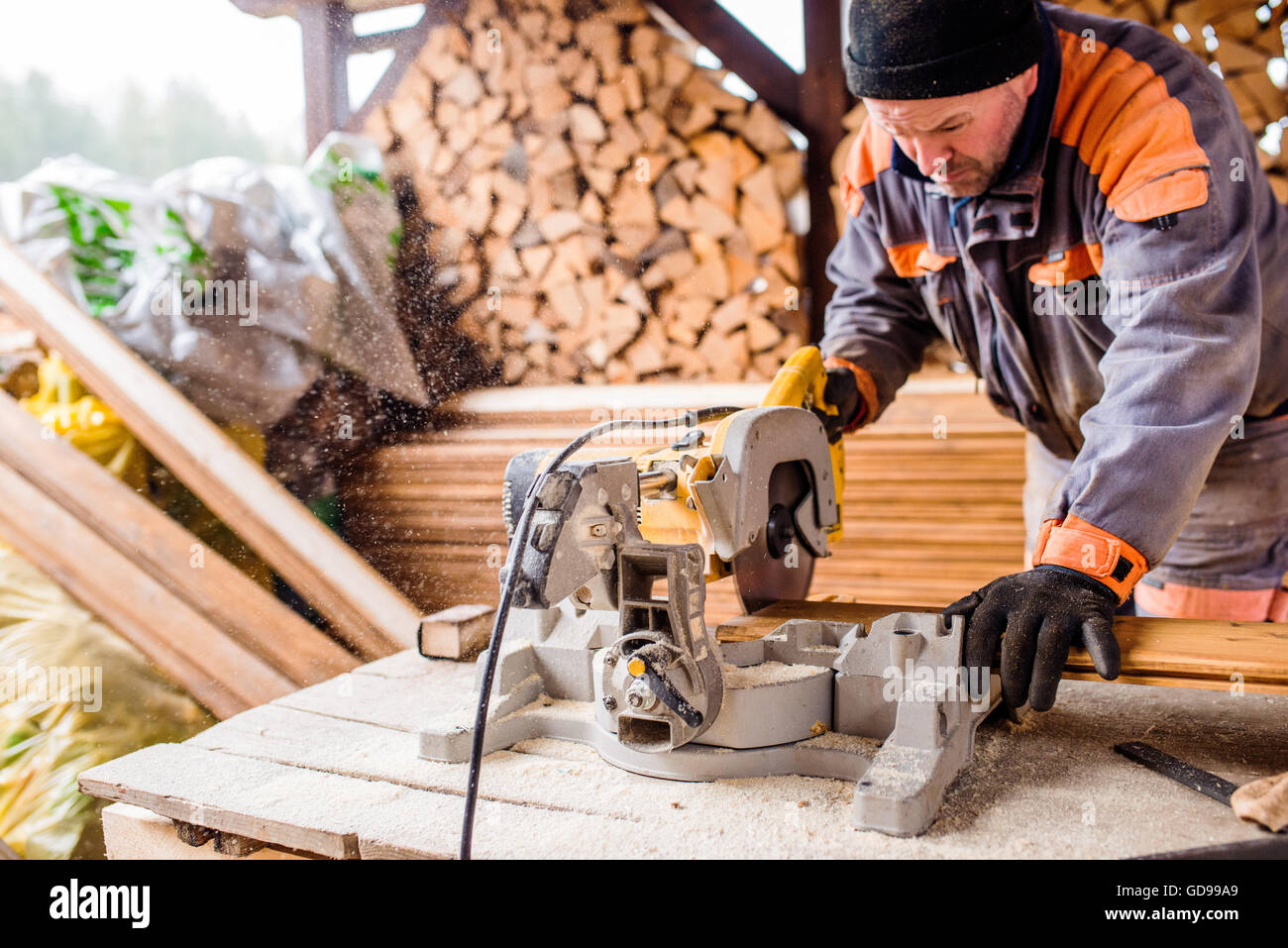 Carpenter working. Man cutting plank by circular saw Stock Photo - Alamy