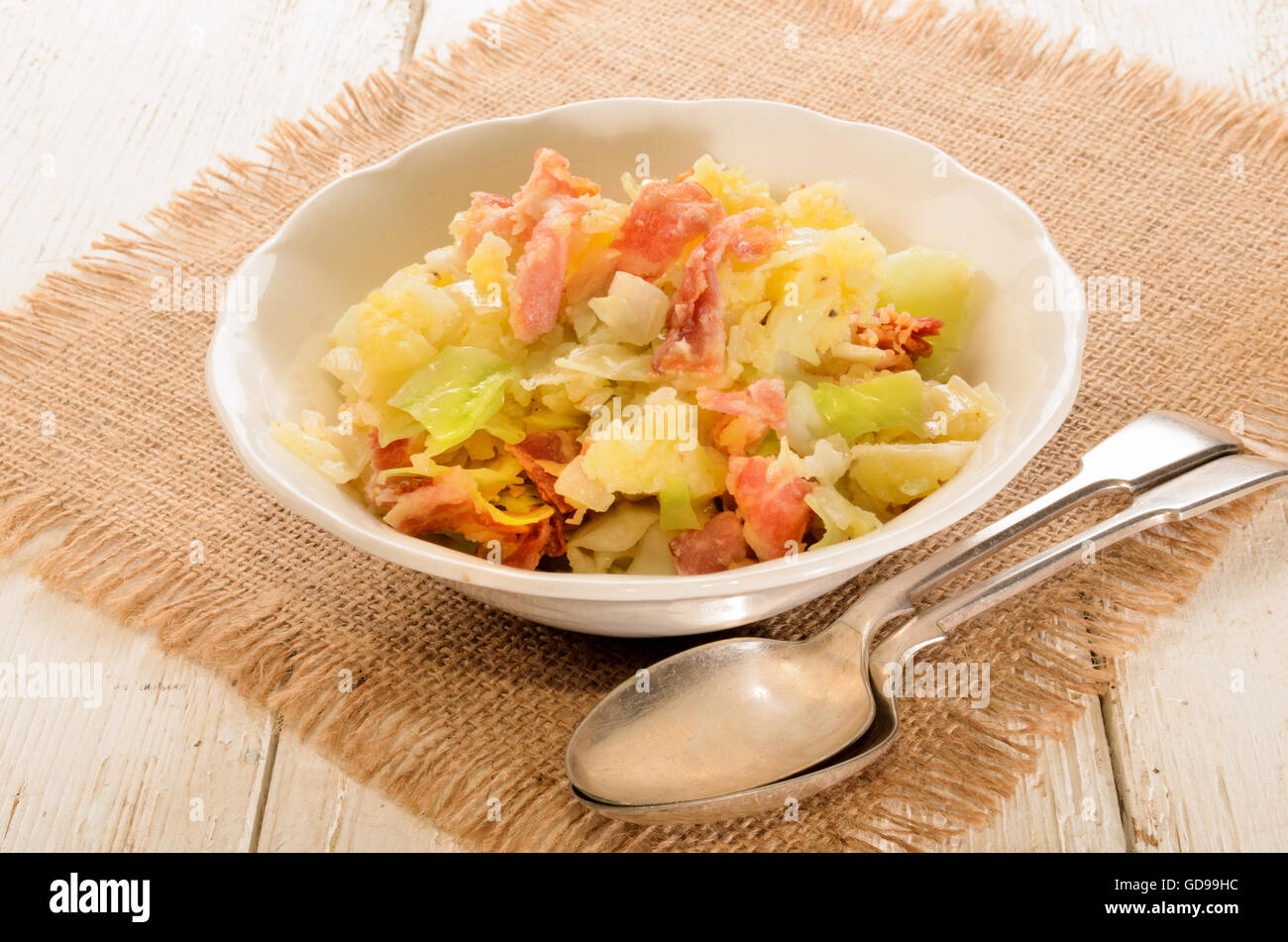 irish colcannon, made with mashed potato, cabbage, grilled bacon and crushes peppercorn in a bowl, with spoon Stock Photo