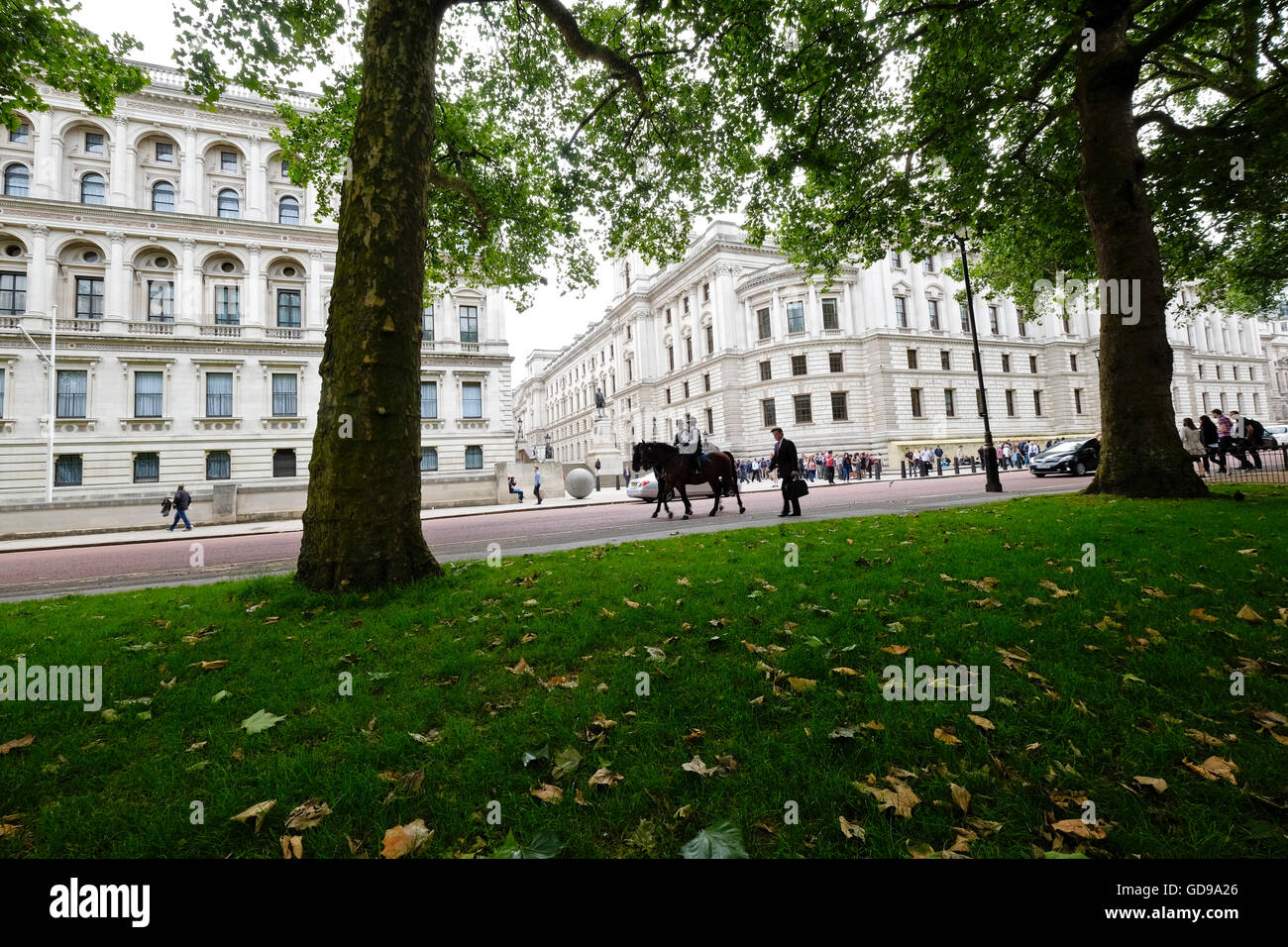 Police on horseback patrol past The Imperial War museum viewed from St James's Park Stock Photo